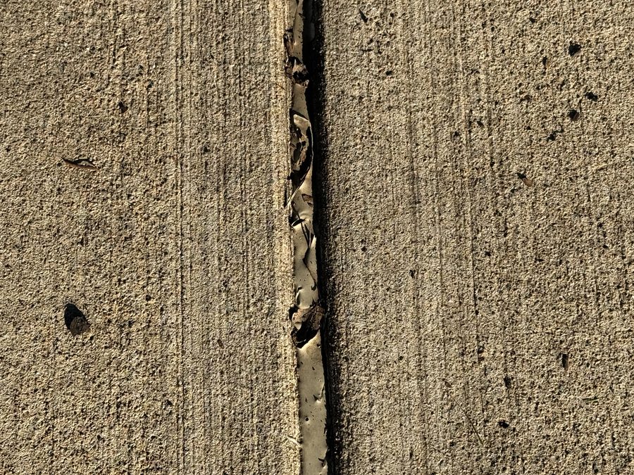 Failed expansion joint filler cracked and collecting debris