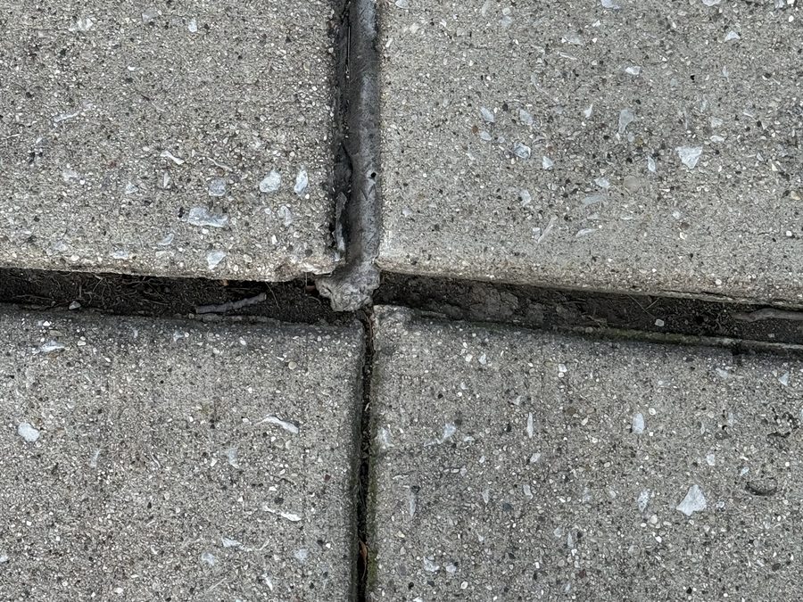 Exposed rotted foam backer rod at a driveway joint intersection