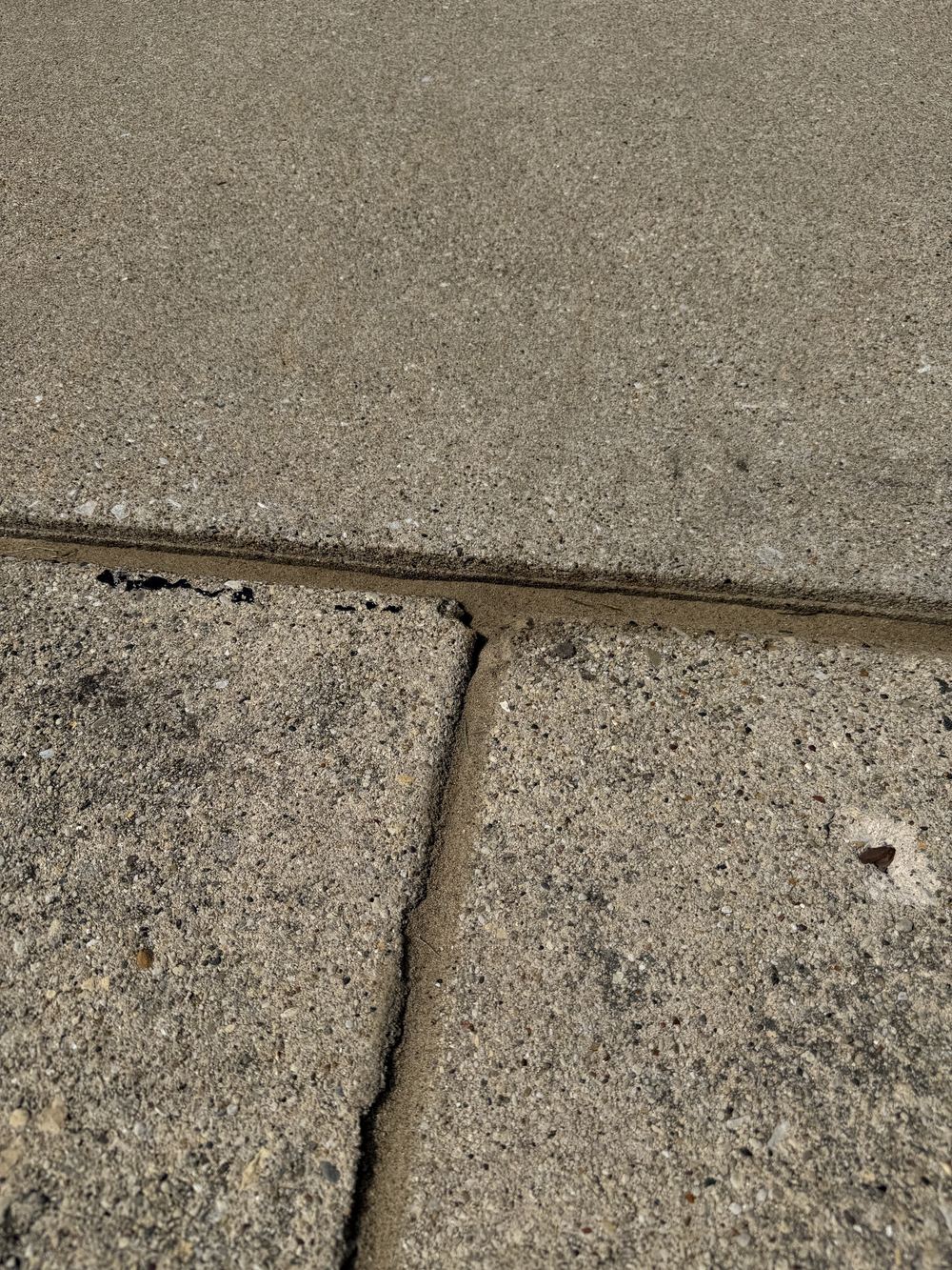 Driveway control joint cleanly sealed and filled flush with the slab
